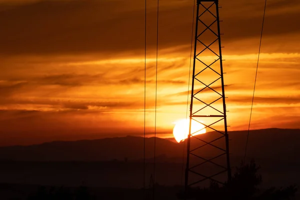 Fiery sunrise in autumn in Czech Moravia and power lines