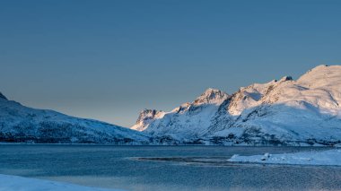 Sunset over the Norwegian fjord, winter photos at the golden hour, Tromso, Norway