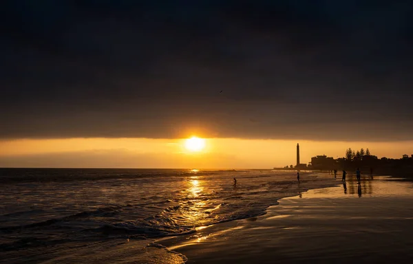 People walking on the beach of Maspalomas at golden hour at sunset, Gran Canaria, Spain,sunset over the sea