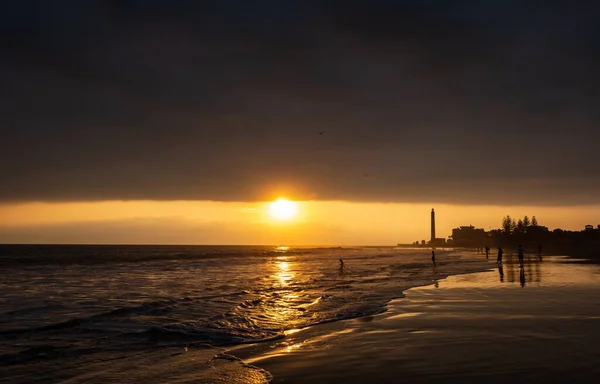 People walking on the beach of Maspalomas at golden hour at sunset, Gran Canaria, Spain,sunset over the sea
