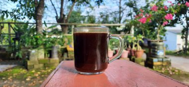 Kafede, açık havada, ahşap masada kahve fincanı.