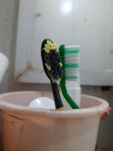 Iki Eski Diş Fırçası Siyah Sarı Beyaz Yeşil Banyoda Pembe — Stok fotoğraf