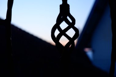 Aşağıdan çekilen çitin silueti ve arka planda mavi gökyüzü