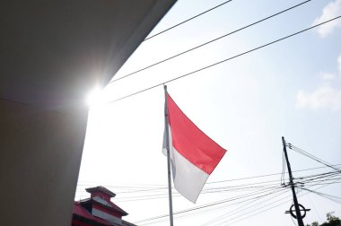 The Red and White flag for Indonesia's independence day with blue sky background