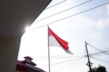 The Red and White flag for Indonesia's independence day with blue sky background