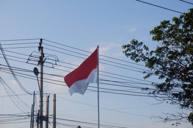 The Red and White flag for Indonesia's independence day with blue sky background