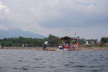 Bagendit Lake tourist attractions with a bamboo boat to play in the middle of the lake.