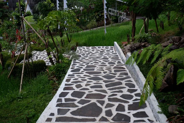 the garden path, lined with natural stone of black and white color