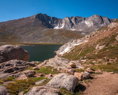 Yazın gökyüzünün altında, Evans Dağı, Colorado 'daki Zirve Gölü' nün kayalık engebeli kıyı şeridi..