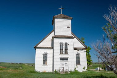 An abandoned and weathered country church in a small town in the Colorado prairie.
