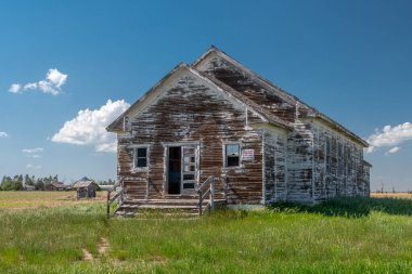 An abandoned and weathered school decaying on the western Nebraska prairie.