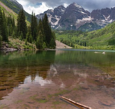 Maroon Bells, Aspen, Colorado yakınlarındaki Maroon Gölü 'nün berrak sularına çok güzel yansıdı..