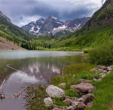 Maroon Bells, Aspen, Colorado yakınlarındaki Maroon Gölü 'nün berrak sularına çok güzel yansıdı..