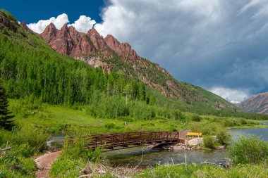 Aspen Colorado yakınlarındaki ünlü Maroon Bells 'in altında Batı Maroon Deresi üzerinde güzel manzaralı bir köprü..