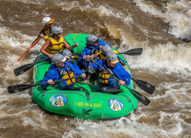 2023 ilkbaharında Arkansas Nehri 'nin dalgalı sularında yüzen bir grup insanın gerçek macera fotoğrafı. Çok fazla yağmur ve karlar eridikten sonra heyecan verici bir kürek çekme için yapılmış..