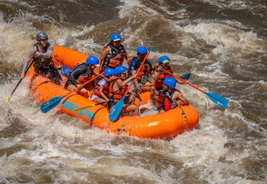 2023 ilkbaharında Arkansas Nehri 'nin dalgalı sularında yüzen bir grup insanın gerçek macera fotoğrafı. Çok fazla yağmur ve karlar eridikten sonra heyecan verici bir kürek çekme için yapılmış..