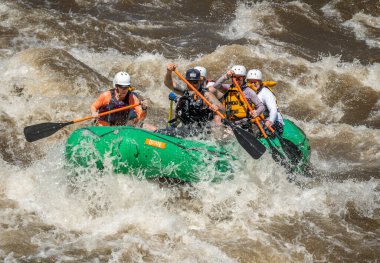 2023 ilkbaharında Arkansas Nehri 'nin dalgalı sularında yüzen bir grup insanın gerçek macera fotoğrafı. Çok fazla yağmur ve karlar eridikten sonra heyecan verici bir kürek çekme için yapılmış..