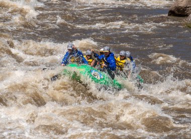 2023 ilkbaharında Arkansas Nehri 'nin dalgalı sularında yüzen bir grup insanın gerçek macera fotoğrafı. Çok fazla yağmur ve karlar eridikten sonra heyecan verici bir kürek çekme için yapılmış..