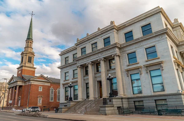 stock image The historic state museum in downtown Denver, Colorado next door to a high reaching old church steeple.