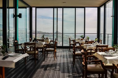 Modern iç mekanlarda masaları olan bir restoran.