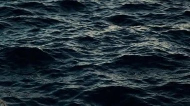 Fırtınada inanılmaz bir arka plan. Dalgalar deniz suyunda sallanıyor. Dalgalarla okyanusun güzel mavi suyu. Yavaş çekim