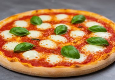Ağız sulandıran taze fesleğen yapraklı ve erimiş mozzarella peynirli margherita pizza. Görüntü sıcaklığı ve İtalyan aşçılık geleneğini çağrıştırıyor..