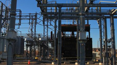 Yüksek voltaj güç şebekesi istasyonu. Sütunlar ve yüksek voltaj aktarımı ve dağıtım güç kabloları. EV için dönüşüm istasyonu altyapısı ve elektrik şebekesi geliştirme.