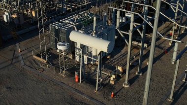 Yüksek voltaj güç şebekesi istasyonu. Sütunlar ve yüksek voltaj aktarımı ve dağıtım güç kabloları. EV için dönüşüm istasyonu altyapısı ve elektrik şebekesi geliştirme.