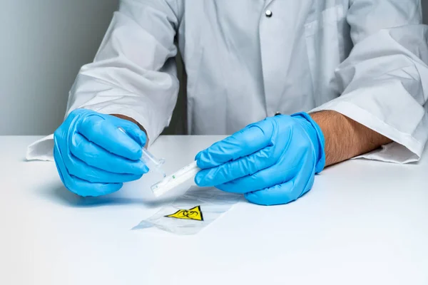 Nurse drops test liquid in rapid test cassette for detection of Coronavirus Covid-19. Antigen rapid test kit. For in vitro diagnostic use only.