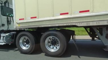 Close up of cargo truck wheels and tires. Passing semi truck on highway. Freight heavy duty vehicle. Canadian commercial industrial tracking, transportation and delivery.