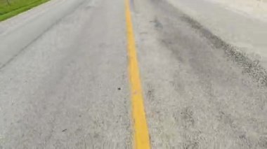 Driving view in the country side travel. Point of view, back car view on asphalt highway road in countryside. Dotted or dashed yellow line on an asphalt road. Fast speed. Moving asphalt view at motorway.