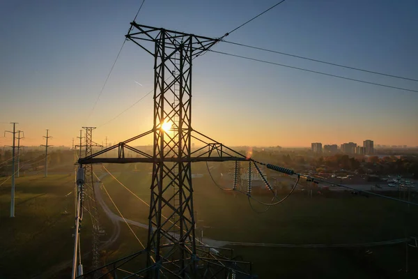 Power tower with electricity. Energy and high voltage electricity pylon at Sunset or golden hour. Power demand and outage blackout concept due EV or electrical vehicle increase. Grid infrastructure.