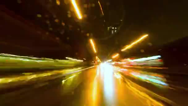 市内の高速道路の長時間露出タイムラップのバックカーウィンドウビュー 夜のシティータイムラプス 夜に車を運転する街 車両バックトランクガラスのカメラ 雨の夜 柔らかい光る — ストック動画