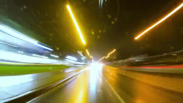 后车窗景观的长期暴露时间间隔的高速公路在城市 城市在夜晚的流逝 在夜晚的城市 摄像头在车辆后备箱玻璃 雨夜柔和的光芒 — 图库视频影像