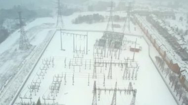 High voltage power grid station at winter storm. Pylons and high voltage transferring and distribution power cables. Transformation station infrastructure and electric power grid development for EV.