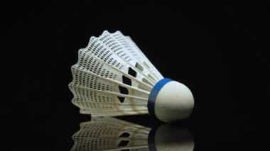 Badminton topu ya da siyah arka planda top rotasyonu. Shuttlecock yaz hobi kitinin bir parçası, makro yakın çekim, sığ alan derinliği. Plastik tüy badminton mekik horozları.