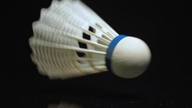 Mekik horozu ağır çekimde düşüyor. Yakın plan ve siyah zemin. Badminton Mekik Horozu yaz hobi kitinin, açık hava sporlarının ve eğlencenin bir parçasıdır..
