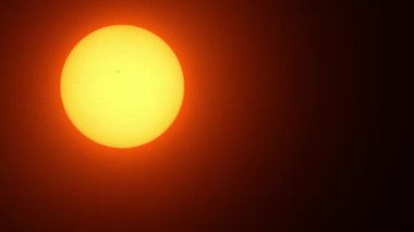 Güneş lekeli, güneşli, güzel bir gün batımı. Güneş filtresiyle yapılmış büyük, sıcak güneş aşırı yakın çekim. Astronomi hobisi. Sıcak yaz atmosferi sıcak hava dalgasında.