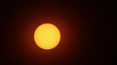Güneş lekeli, güneşli, güzel bir gün batımı. Güneş filtresiyle yapılmış büyük, sıcak güneş aşırı yakın çekim. Astronomi hobisi. Sıcak yaz atmosferi sıcak hava dalgasında.