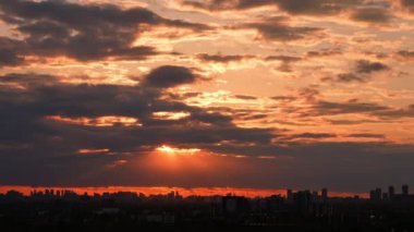 Güzel Günbatımı Güneş Siren Bulutları Renkli Gökyüzünde güneş ışınlarıyla. Zaman aşımı. Şehir manzarası üzerinde kırmızı turuncu sarı gökyüzü. Sunset 'te bulutlar ve güneş. Çok Renkli Akşam Programı Ufuk Şehri.