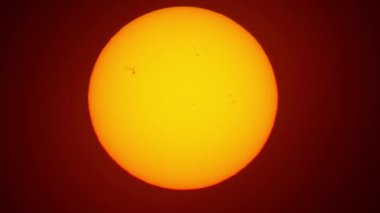 Güneş lekeli, güneşli, güzel bir gün batımı. Güneş filtresiyle yapılmış büyük, sıcak güneş aşırı yakın çekim. Astronomi hobisi. Sıcak yaz atmosferi sıcak hava dalgasında.