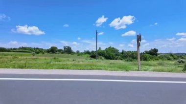 Ön yolcu koltuğunun sağ tarafındaki araç görüntüsü. Yolcu penceresi yan sürüş manzarası. Çiftçilerin rüya tarlası POV 'u Ontario King' s Highway 28 'de, yemyeşil tarlayı geçiyor..