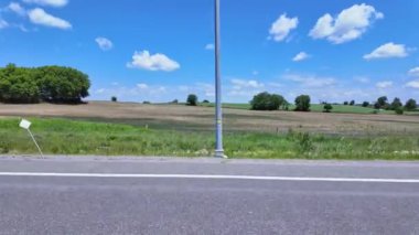 Ön yolcu koltuğunun sağ tarafındaki araç görüntüsü. Yolcu penceresi yan sürüş manzarası. Çiftçilerin rüya tarlası POV 'u Ontario King' s Highway 28 'de, yemyeşil tarlayı geçiyor..