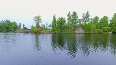 Kuzey kır evindeki Kanada Gölü 'nün Idyllic manzarası. Kuzey cenneti manzarası ve vahşi doğa manzarası. Muhteşem kayalık oluşumları ve ladin bitkilerini keşfeden bir tekne gezisi..