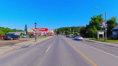 28. otoyol boyunca küçük bir kasabanın arka geniş görüş alanı var. Oradan geçen ev ve iş yerleri. Arabanın arkasından asfalt yol manzarası: Bancroft, Kawartha, Ontario, Kanada - 28 Haziran 2024