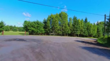 28. otobanın geniş açılı çekim plakalı kamera pov 'u Kanada kalkanının yeşillik bolluğunu geçiyor. Arabanın arkasından asfalt yol manzarası: Bancroft, Kawartha, Ontario, Kanada - 28 Haziran 2024