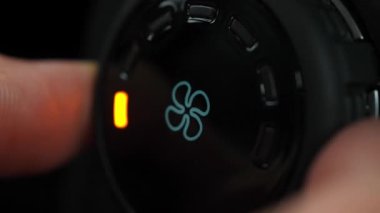 Sürücü, hava akışını kontrol düğmesiyle LED statüsünü değiştirerek değiştiriyor. Makro, kapat. Kadın vantilatör hızını arabanın havalandırma sistemine göre ayarlıyor..