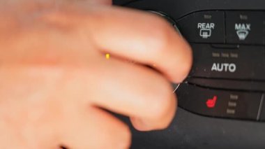 Kadın vantilatör hızını arabanın havalandırma sistemine göre ayarlıyor. Hava akışını, LED durumu ile iklim kontrol düğmesi düğmesini değiştirerek değiştiriyor. Makro, kapat..