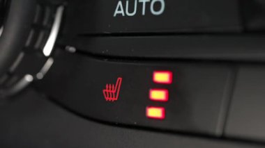 Isıtmalı araç koltuğu ısıtıcıları kontrol etmek için şoför tarafından itilmiş. Araba koltuğu ısıtması için parmak düğmesine bas. Araç soğuk hava ısısı koltukları sistemi.