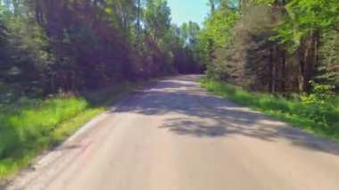 Motokros yarışçısı plaka kullanıyor, engebeli off-road 'a biniyor, dağlarda hızlı sürüş yapıyor, aşırı maceralar yaşıyor. Arka plan Sürücü Plakası Kırsal yolda geriye doğru bakıyor.